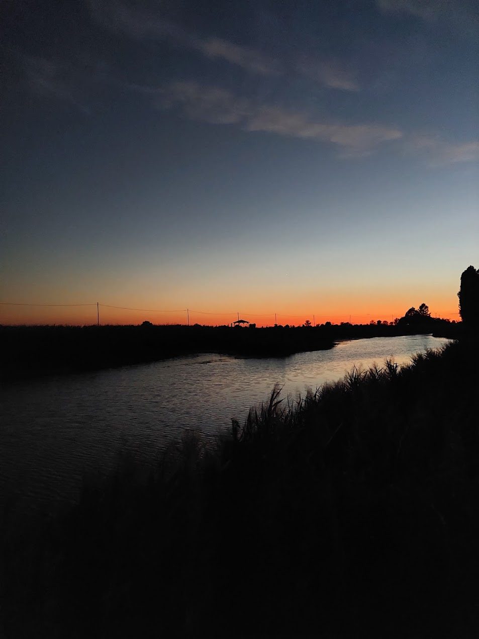 Sunset over the waterway in front of the farmhouse