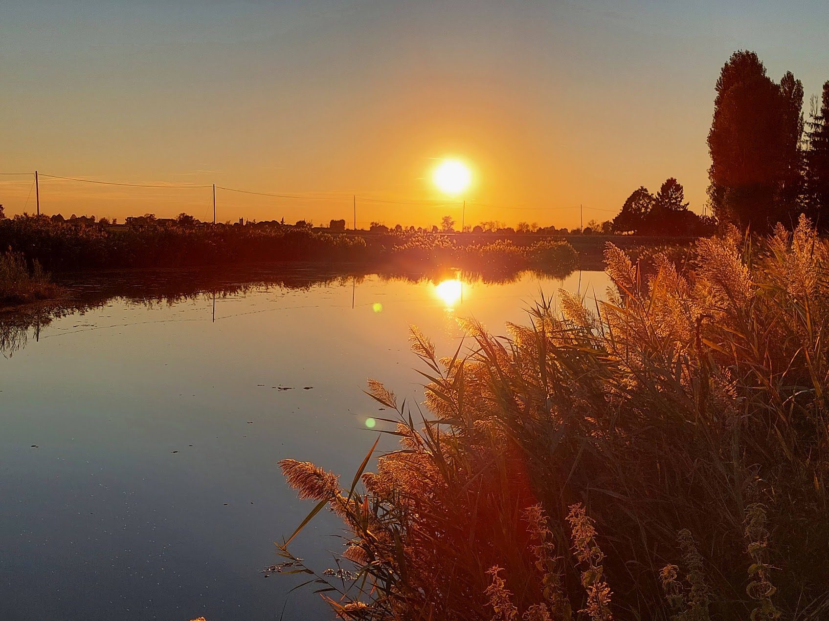 Sunset over the waterway in front of the farmhouse
