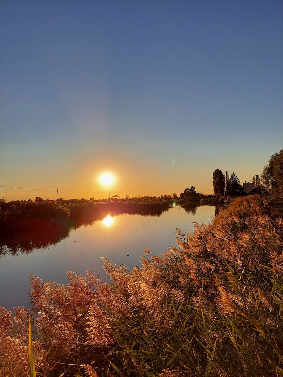 Sunset over the waterway in front of the farmhouse